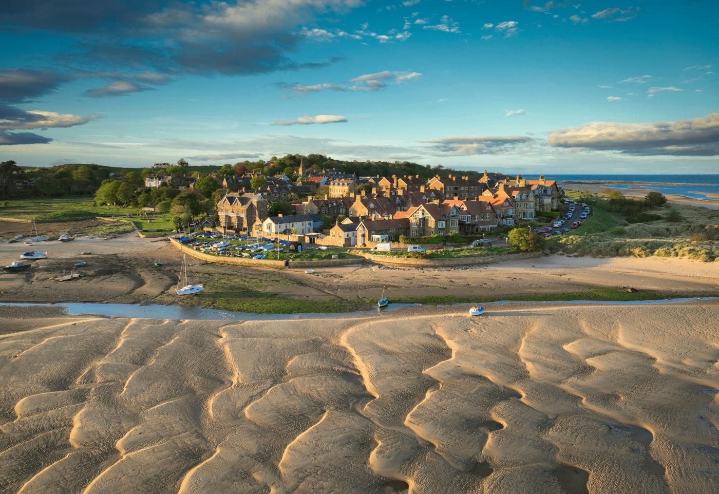 Une ville côtière dotée d’un ensemble de bâtiments imposants, de plages de sable et de bateaux.