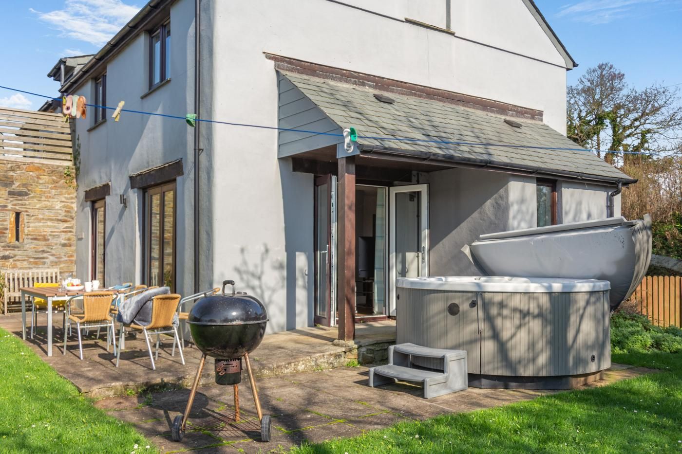 Una casa moderna con patio, barbecue e vasca idromassaggio.