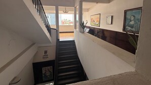 A hotel interior with a staircase, a reception desk, and artwork on the walls. - EL BARON HOTEL (Tapachula)
