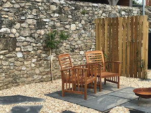 A stone wall, wooden chairs, a wooden fence, and a metal fire pit. - 1 Bed in Thorncombe (oc-t34792) (Thorncombe)