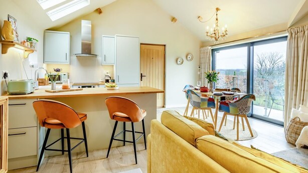 Una cocina moderna con comedor, sofá y un amplio ventanal con vistas.