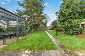 A covered patio area with a table and chairs, a pathway, and a lamp post. - 3 Bed in Stratton Strawless (oc-w34832) (Stratton Strawless)