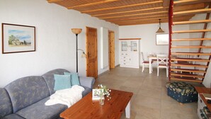 Una sala de estar con sofá, mesa de centro y una escalera.