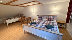 Una camera da letto con un letto, due comodini, una sedia e un tavolino.