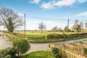 A rural road with a white fence, a grassy field, and a clear sky. - 2 Bed in Hunningham (oc-h34740) (Hunningham)