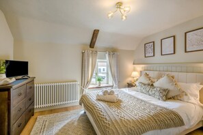 A bedroom with a bed, a dresser, a radiator, a television, and a window with curtains. - 1 Bed in Holt (oc-p34797) (Holt)