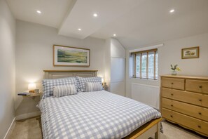 A bedroom with a bed, bedside tables, a dresser, a window with blinds, and a painting on the wall. - 2 Bed in Dersingham (oc-o34800) (Dersingham)