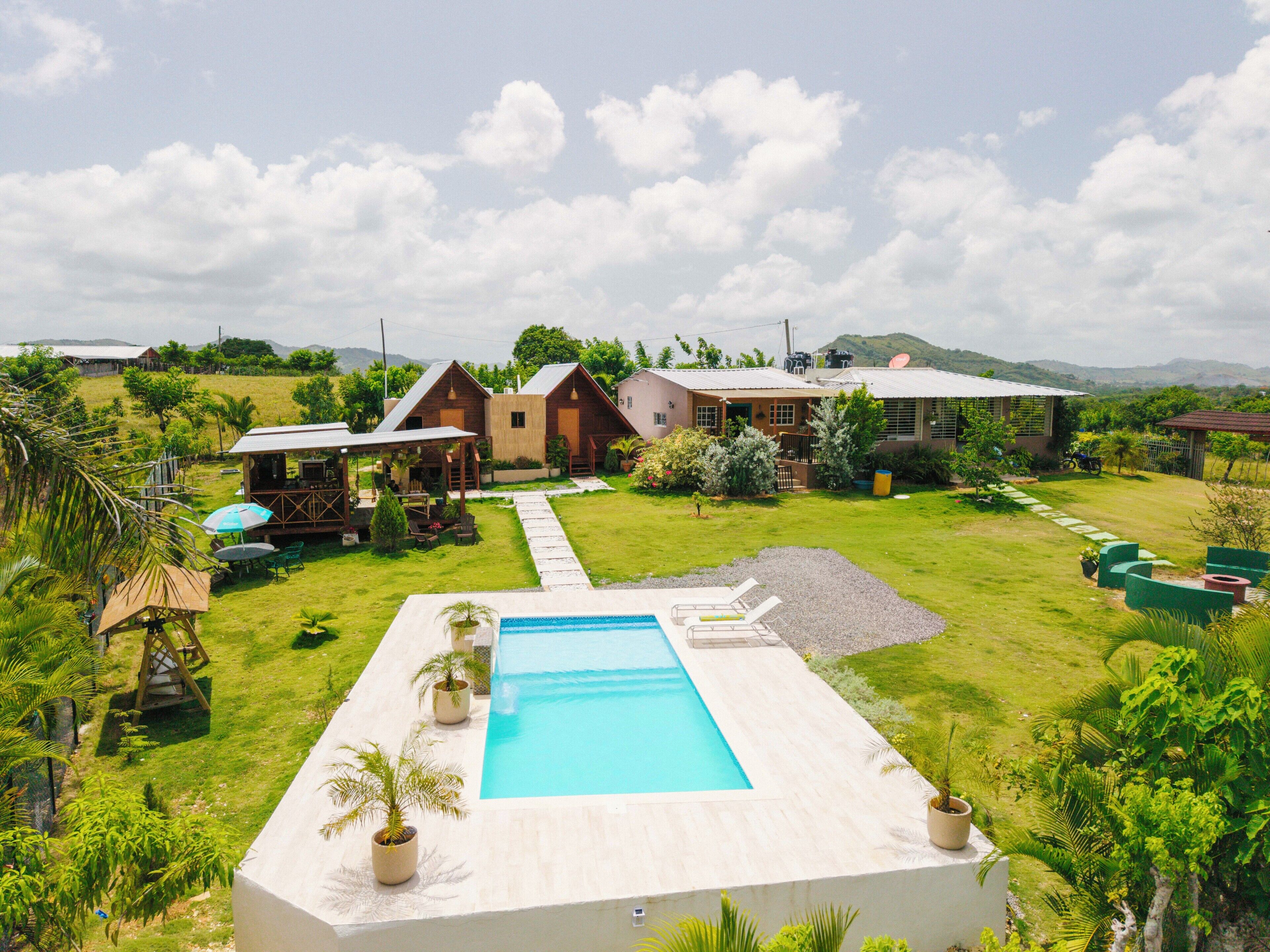 A pool area with a clear view of the surrounding landscape, including a house and a mountain in the background.