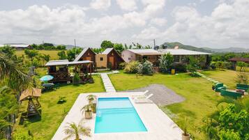 A pool area with a clear view of the surrounding landscape, including a house and a mountain in the background.