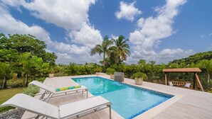 A rectangular swimming pool with a tiled edge, surrounded by a wooden deck. - Villa Campestre by Otium (Higüey)