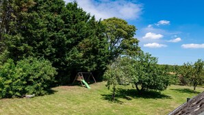 Un espace extérieur verdoyant avec une balançoire et des arbres.
