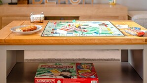 Ein Monopoly-Spiel auf einem Holztisch, darunter die Spielbox.