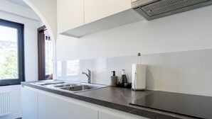 Eine moderne Küche mit einer großen Kochinsel, Edelstahlgeräten und einem Fenster für natürliches Licht.