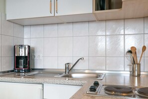 A kitchen with a coffee maker, a sink, and a stove. - Ferienwohnung mit Moblierten Balkon in Sellin (Sellin)