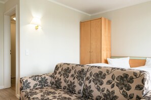 A room with a sofa, a wardrobe, and a bed. - Ferienwohnung mit Moblierten Balkon in Sellin (Sellin)
