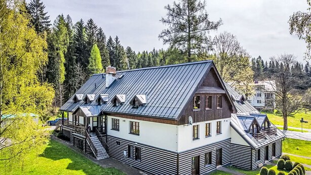 A modern house with a sloped roof, a covered porch, and a well-maintained lawn. - Cosy apartment for 4 people with WIFI and TV (Jilemnice)