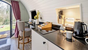 Une cuisine moderne équipée d’une cuisinière intégrée, d’une machine à café et d’un bloc à couteaux.