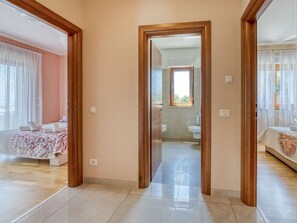 Una habitación de hotel con cama, baño con lavamanos e inodoro, y vistas al exterior.