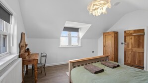 A bedroom with a sloped ceiling, a wooden bed, a desk with a chair, a window, and a door. - 1 Bed in Bontuchel (oc-t34921) (Bontuchel)