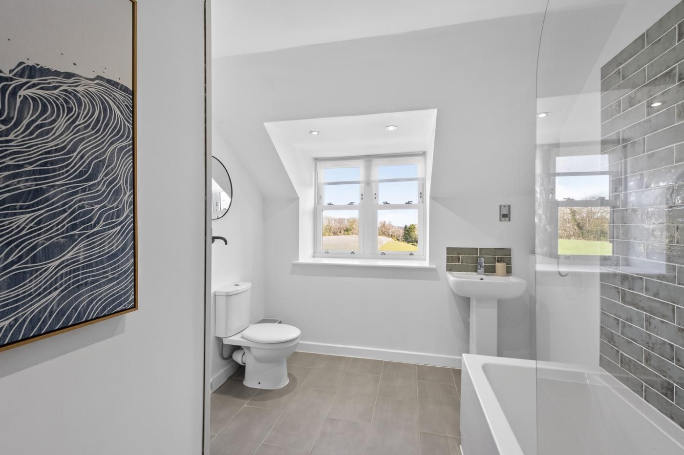 A modern bathroom with a toilet, sink, and shower area.