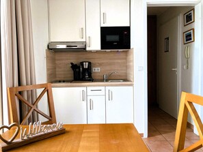 A compact kitchen with a coffee maker, microwave, and a small sink. - Komfortable Ferienwohnung im Seepark Sellin mit Balkon (Sellin)