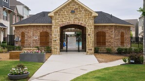 A stone building with a central archway, numbered 4369, and a gated entrance. - New Townhouse near DFW FIFA ATT STADIUM (North Richland Hills)