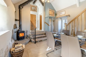 Ein gemütliches Interieur mit Kamin, Essbereich und Treppe.