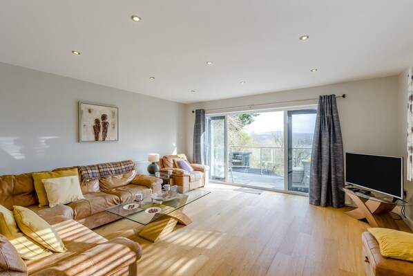 A spacious living room with a sofa set, a coffee table, and a television.