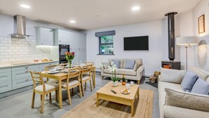 Ein moderner Wohnraum mit Essbereich, Sofa und Kamin.