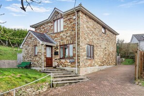 A stone building with a front entrance, steps, and a green bench outside. - 3 Bed in Polruan (oc-l35010) (Fowey)