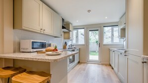 Eine Küche mit Mikrowelle, Toaster und Holzschemeln.