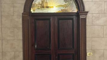 A dark wooden double door with a decorative glass window above it.