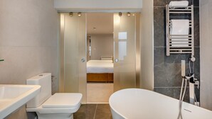 Une salle de bain moderne équipée d’une baignoire, de toilettes et d’une douche.