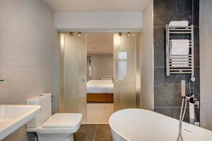 Ein modernes Badezimmer mit Badewanne, Toilette und Dusche.