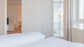 Habitación de hotel con cama, una silla y vistas al exterior.