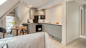 A compact kitchen with a dining area, a built-in oven, and a microwave. - 1 Bed in Keswick (oc-t35027) (Keswick)