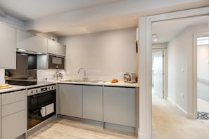 A modern kitchen with a built-in oven, microwave, and stainless steel appliances. - 1 Bed in Keswick (oc-t35027) (Keswick)