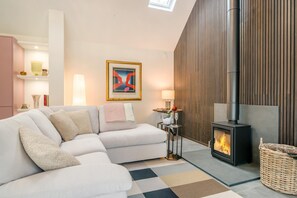 A modern living room with a sectional sofa, a fireplace, and a contemporary art piece on the wall. - 2 Bed in Plymtree (oc-r35085) (Plymtree)