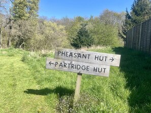 Un senyal de fusta amb fletxes que indiquen 'Pheasant Hut' i 'Partridge Hut'.