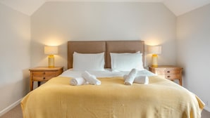 Une chambre d’hôtel avec un grand lit, deux tables de chevet et deux lampes.