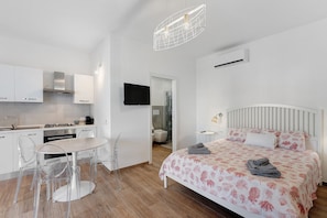 Un dormitorio moderno con una cama, una mesita de noche y un televisor montado en la pared.