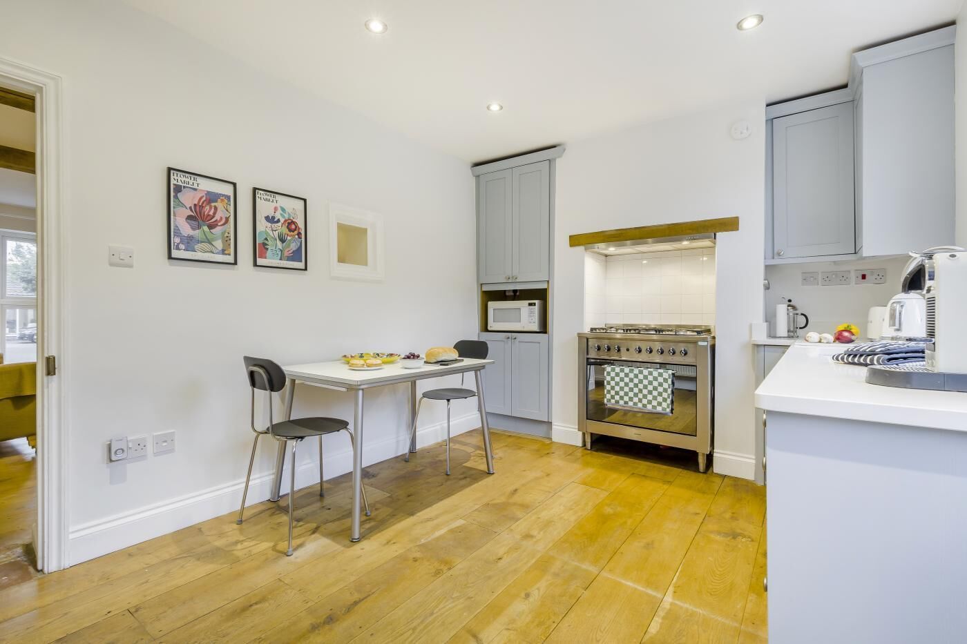 Una cucina moderna con un tavolo da pranzo, sedie, un fornello e un forno a microonde.