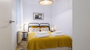 A bedroom with a bed, a bedside table, a lamp, a picture on the wall, and a window. - Central Haven near Museums (Madrid)