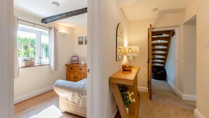 A bedroom with a bed, a wooden dresser, a bedside table with a lamp, a window with curtains, and a staircase leading to another room. - 4 Bed in Ireby (oc-p34997) (Ireby)