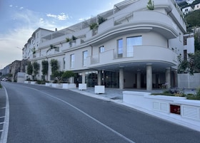 Un hotel moderno con fachada curva, ventanas amplias y una zona de entrada cubierta.