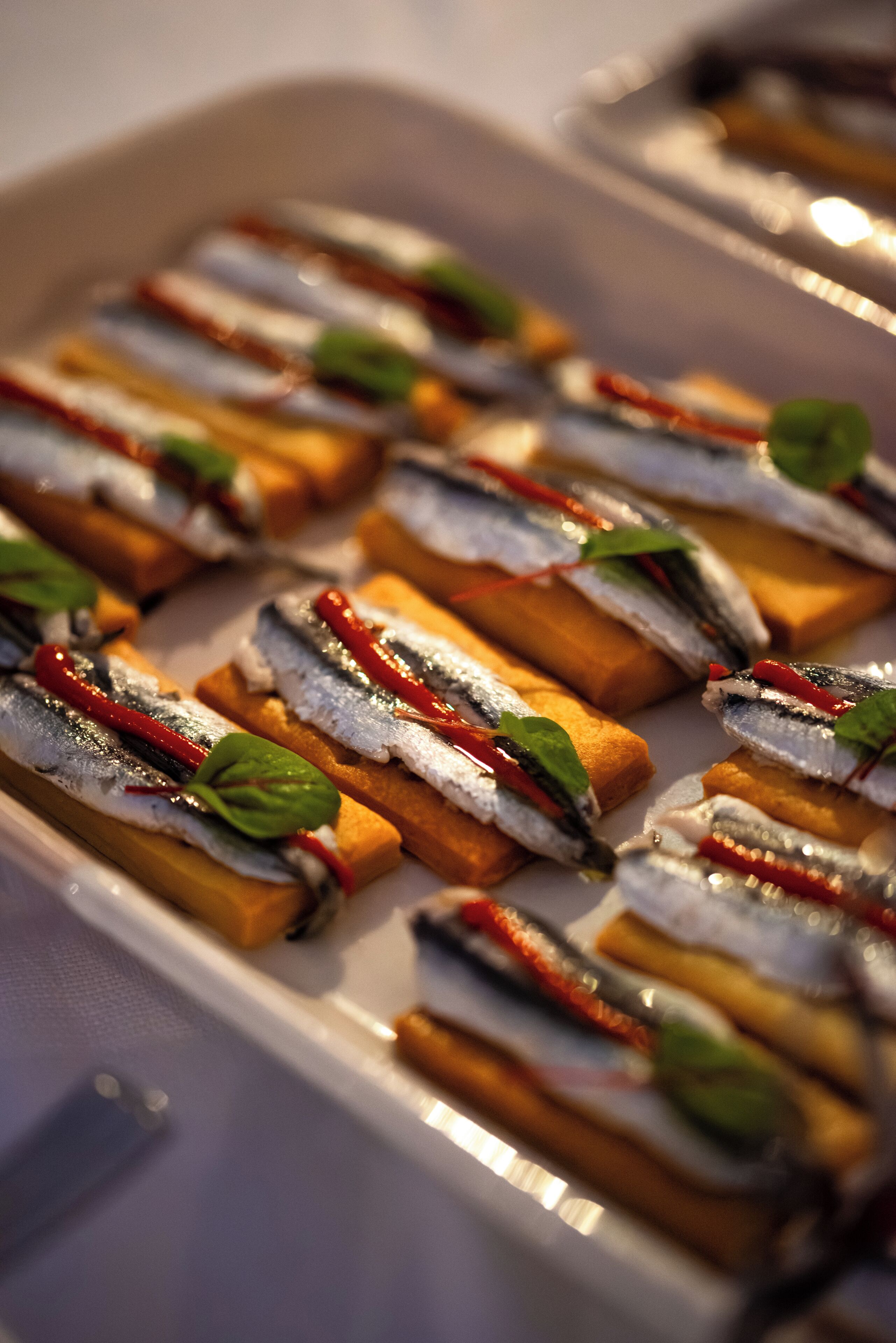 A tray of appetizers with fish and vegetables.