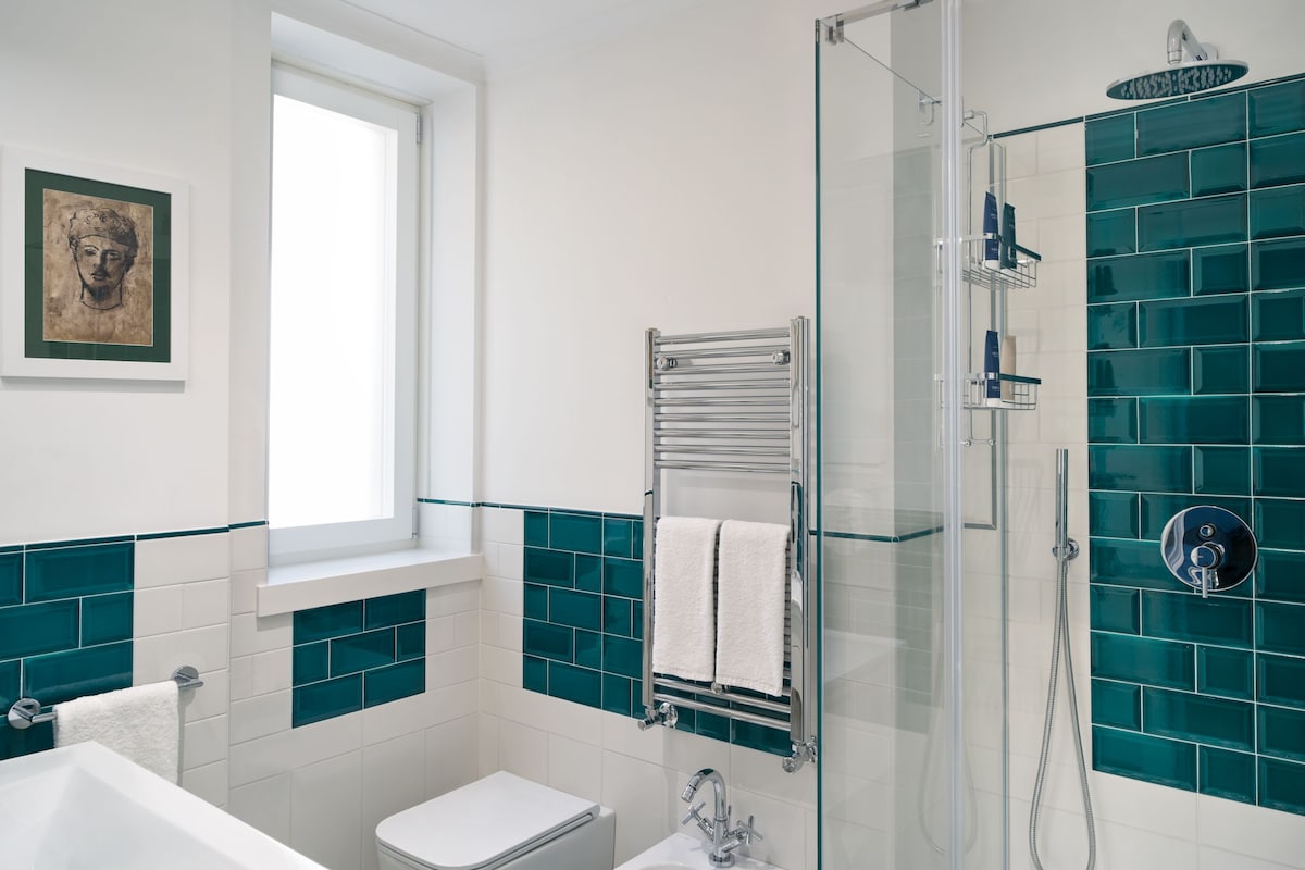 Un baño moderno con cabina de ducha de vidrio, inodoro blanco y bañera.