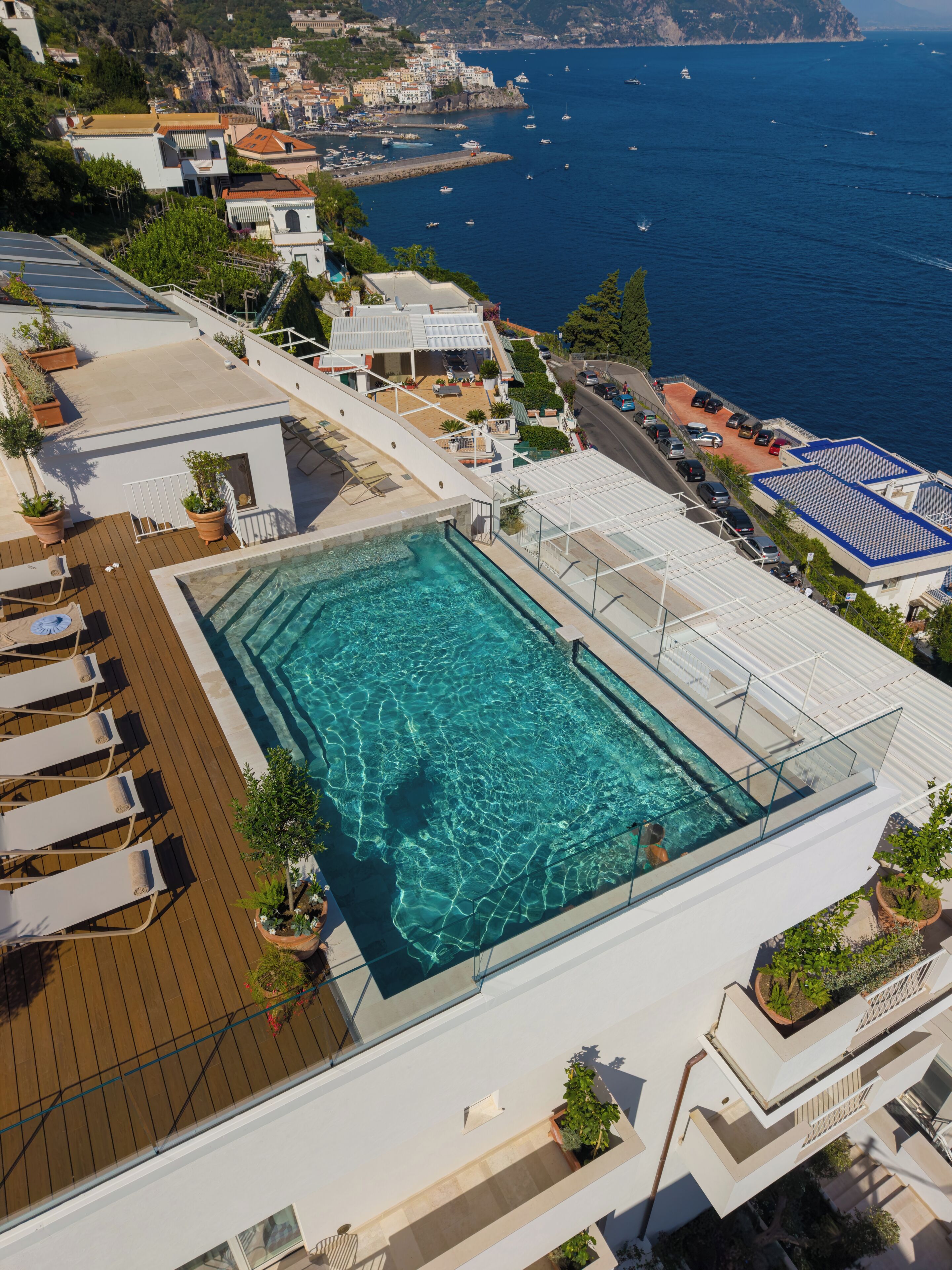 Una piscina en la azotea con vista al mar y al paisaje urbano.