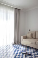 Una habitación con sofá, una mesita redonda y piso con diseño.
