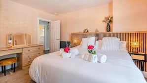 Una habitación de hotel con cama, mesitas de noche, un escritorio y una silla.